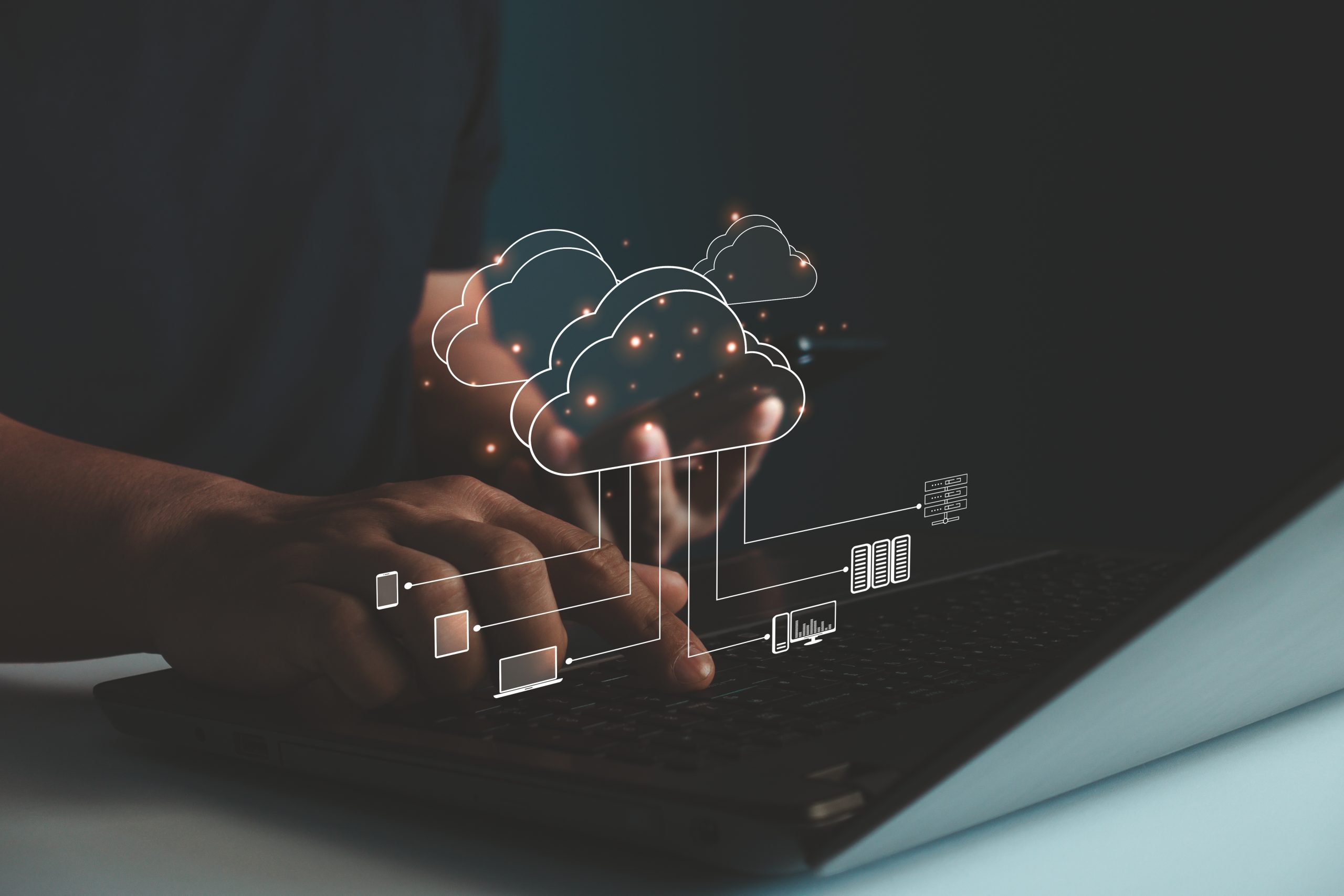 A person typing on a laptop with a glowing cloud computing graphic overlay, representing data transfer, multicloud strategies, and advanced cloud architecture concepts.