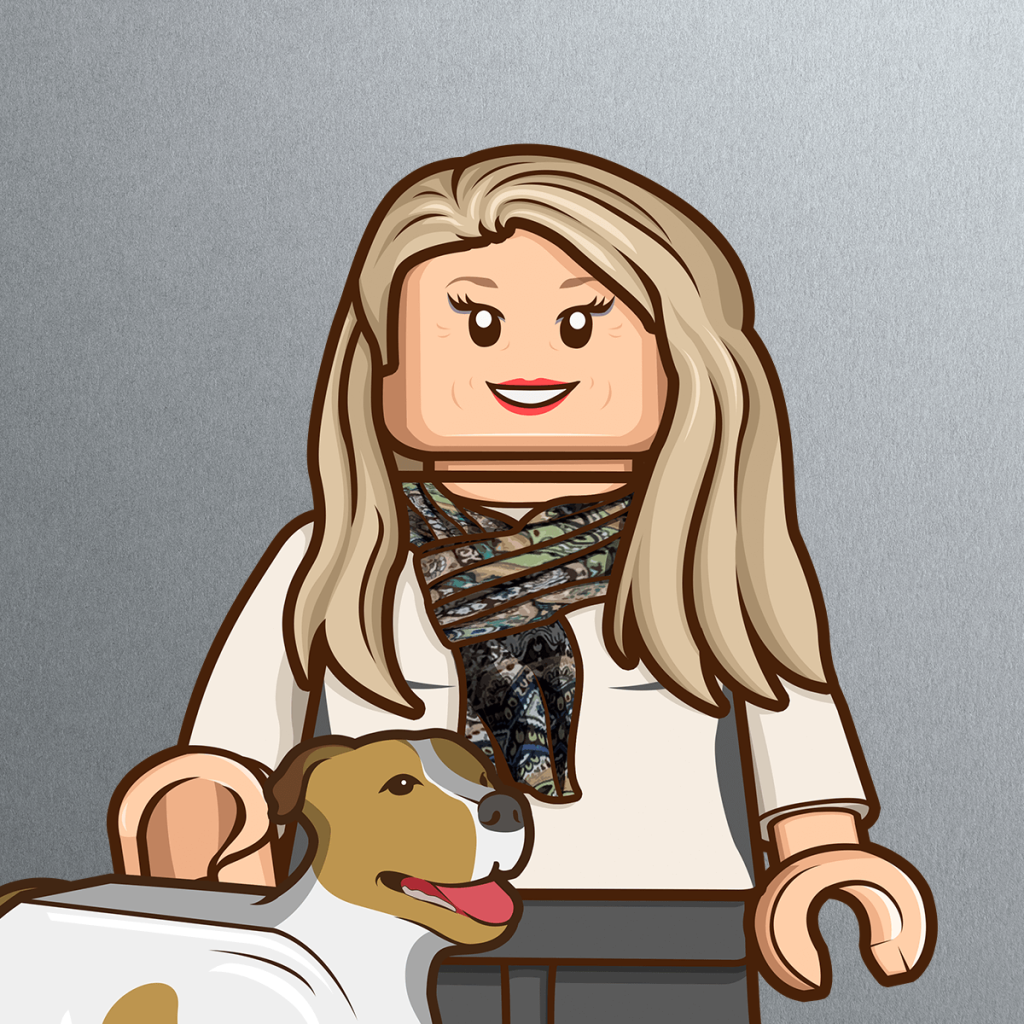 A LEGO-style figure resembling Pamela Craven, with long blonde hair, a colorful patterned scarf, and a white shirt stands smiling, holding the leash of a brown and white dog against a gray background.