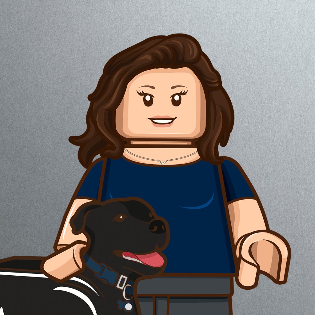 A LEGO-style illustration of a woman with wavy brown hair, smiling and wearing a navy blue top, standing next to a black dog with a blue collar. The background is a plain, metallic gray.