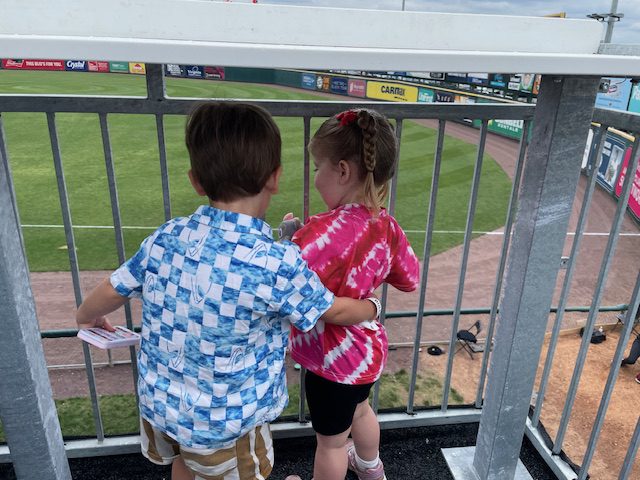 Nutasha and two children enjoy the baseball game together.