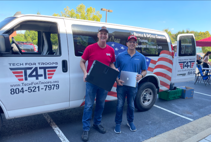 Two males next to a van featuring the American flag.